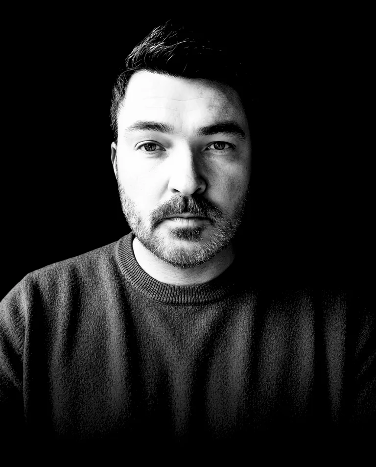 MRCIER, DJ from Annecy: black and white portrait, looking straight into the lens, dark sweater on a black background